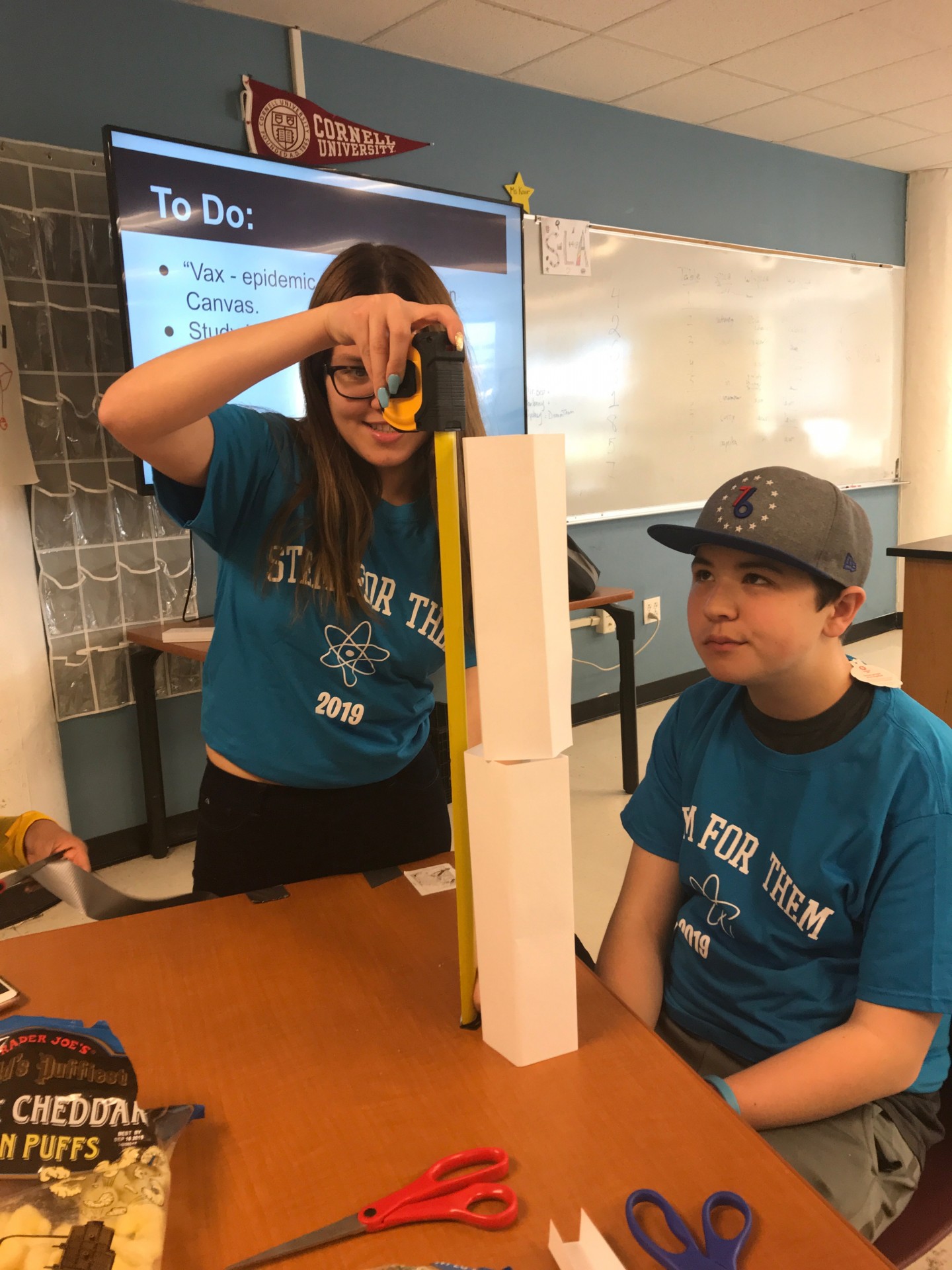 Measuring the length of Max's paper tower after completing the NCOTI inspired activity.