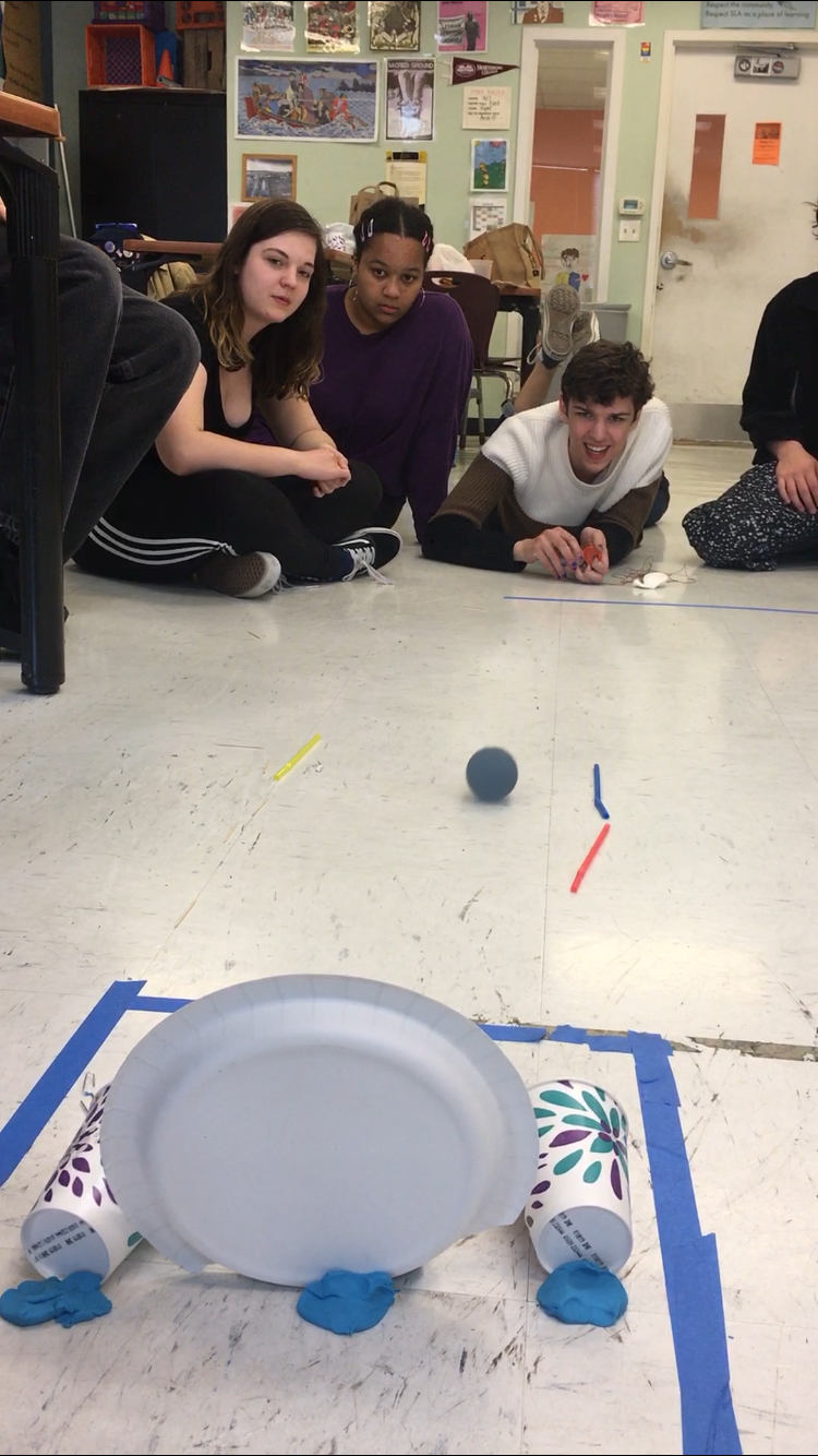 Team 2 performing their solution to the same prompt with the same constraints, but with a totally different approach. They created a corral to trap the balls they rolled in the scoring area.